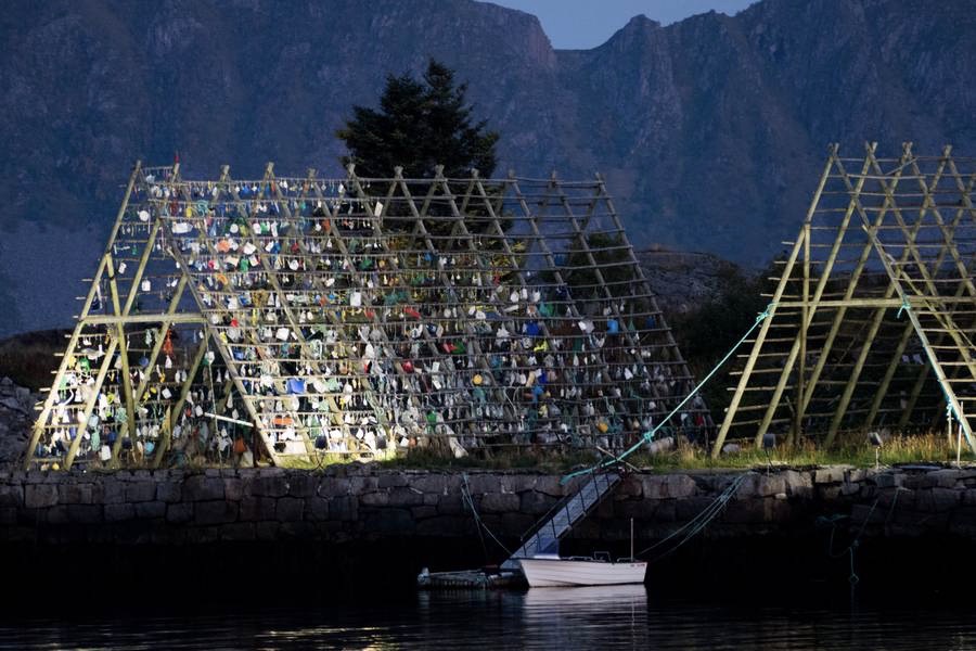 Kunstværket på tørfisk-stativet tager form i Lofoten. Det ophængte affald er indsamlet af Hurtigrutens passagerer. Foto: Søren Stidsholt Nielsen, Søsiden, Fyns Amts Avis