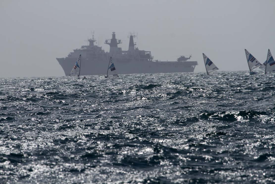 Et krigsskib passer på sejlerne.